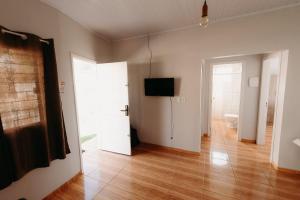 uma sala de estar vazia com uma televisão e uma porta em casa em LAGES 2 km do centro LAGES em Lages