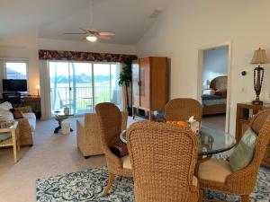 a living room with a glass table and wicker chairs at Ko Olina Ocean View Home Office in Kapolei