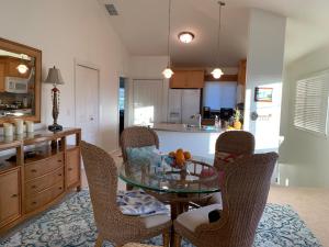 a kitchen with a glass table and two chairs at Ko Olina Ocean View Home Office in Kapolei