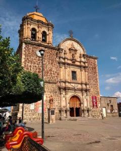 um grande edifício com uma torre de relógio em frente em Hotel Abasolo em Tequila