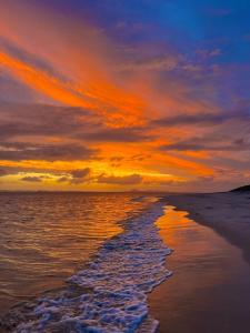 - un coucher de soleil sur une plage donnant sur l'océan dans l'établissement Great Keppel Island Hideaway, à Great Keppel