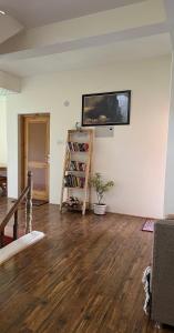 a living room with a tv and a book shelf at Heschuk Guest House in Leh