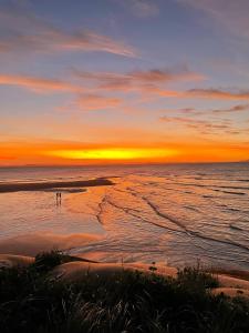 グレート・ケッペルにあるGreat Keppel Island Hideawayの夕日の海に立つ者