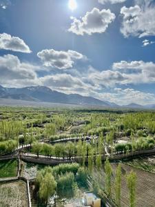 - une vue aérienne sur un parc avec des arbres et des montagnes dans l'établissement Heschuk Guest House, à Leh