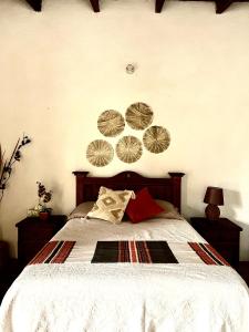 a bedroom with a bed with four plates on the wall at Cabaña en Malinalco Zarla in Malinalco
