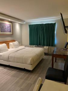 una camera con letto, scrivania e finestra di 777 Motor Inn a Huntington Beach