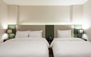 twee bedden naast elkaar in een kamer bij Hotel Yaja Gwangalli in Busan
