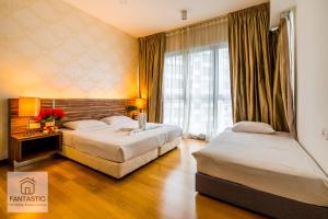 ein Hotelzimmer mit 2 Betten und einem Fenster in der Unterkunft Regalia Residence @ KLCC View Sky Pool by MC in Kuala Lumpur