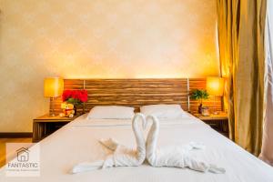 duas toalhas brancas numa cama num quarto de hotel em Regalia Residence @ KLCC View Sky Pool by MC em Kuala Lumpur