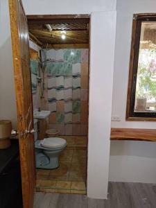 a bathroom with a toilet and a sink at Treehouse Front Beach Bacong in Bacong