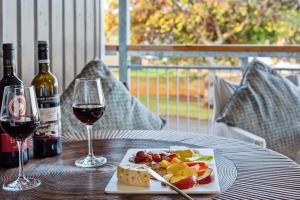 een tafel met een bord eten en twee glazen wijn bij Scarborough beach break holidays - Unit 2 in Scarborough