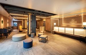 a lobby with a salon with chairs and tables at HOTEL AMANEK Shinjuku Kabukicho in Tokyo