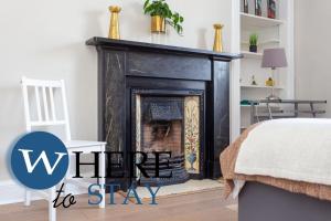 una sala de estar con chimenea con las palabras invierno para alojarse en Bright 2 bed apartment by Rodney st, en Edimburgo