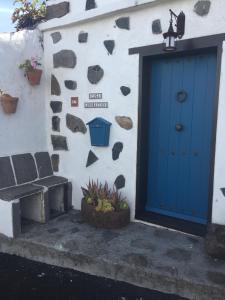 una puerta azul en el lateral de un edificio con un banco en Casa rural Adoracion Chipude - Adults Only, en Chipude