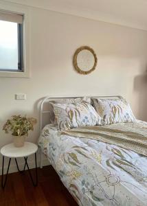 Un dormitorio con una cama con una planta. en GARDEN CUBBY - The Lakeside Haven, en Lake Illawarra