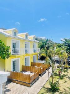 una grande casa gialla con terrazza in legno di Canaan B&B Kenting a Eluan