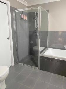 a bathroom with a shower and a toilet at GARDEN CUBBY - The Lakeside Haven in Lake Illawarra