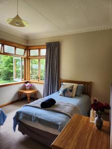 1 dormitorio con cama, mesa y ventanas en Caithness en Roxburgh