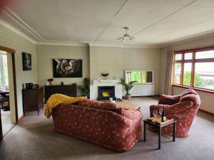 sala de estar con 2 sofás y chimenea en Caithness en Roxburgh