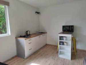 a kitchen with white cabinets and a counter top at Logement cozy avec Jardin in Arue
