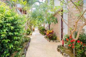 a walkway in a greenhouse with flowers and plants at Shanban Bay Homestay in Xiaoliuqiu