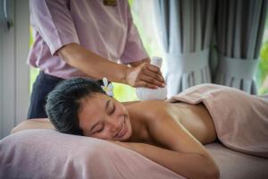 a woman laying on a bed getting a massage at Farmhouse Resort & Spa in Kampong Chhnang