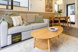 uma sala de estar com um sofá e uma mesa em The Majestic retreat 2 bed 2 bath CBD em Christchurch