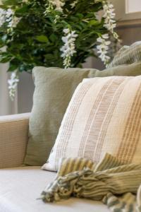 a pillow on a couch with a plant in the background at The Majestic retreat 2 bed 2 bath CBD in Christchurch