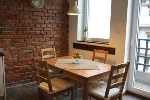 a dining room table with chairs and a brick wall at Del Toro Apartment in Skopje