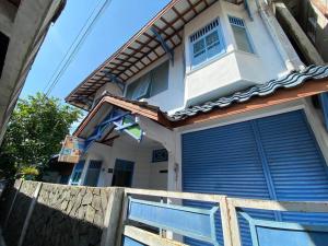 uma casa com portas azuis e uma bandeira em Singgah Macanan em Sentool