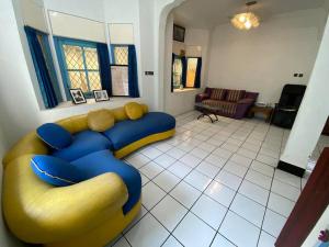 uma sala de estar com um sofá amarelo e azul em Singgah Macanan em Sentool