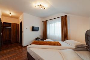 una camera d'albergo con due letti e una finestra di Watra Chalet a Vatra Dornei