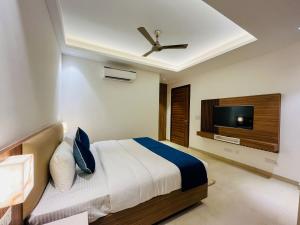 sypialnia z łóżkiem i telewizorem z płaskim ekranem w obiekcie Inception Residence w mieście Gurgaon