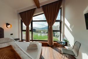 a bedroom with a bed and a large window at Watra Chalet in Vatra Dornei