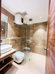 y baño con aseo y ducha acristalada. en Inception Residence, en Gurgaon