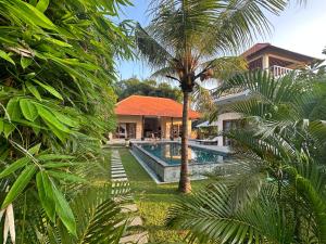 una casa con una piscina y una palmera en Villa Light - Amed Bali, en Amed