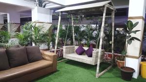 a swing with purple pillows in a room with plants at UNIQUE HOMESTAYS in Kondapur