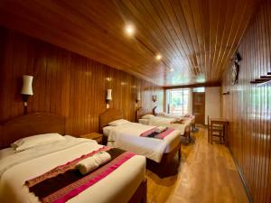 una camera con 4 letti in una stanza con pareti in legno di Mistico Machupicchu Eco B&B a Machu Picchu