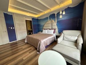 um quarto com uma cama, um sofá e uma cadeira em Song Xia Motel em Dali