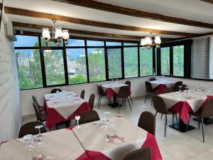 ein Esszimmer mit Tischen, Stühlen und Fenstern in der Unterkunft Casa Michela in Caporciano