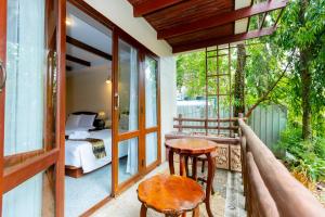 Ao Nang Bay Resort في شاطيء آونانغ: شرفة مع طاولة وسرير وغرفة نوم