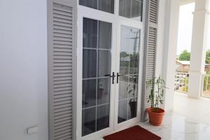 una puerta corredera de cristal con una maceta en el balcón en The Ellysian Apartments en Placencia Village