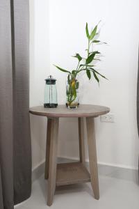 uma mesa de madeira com uma planta num vaso sobre ela em The Ellysian Apartments em Placencia Village