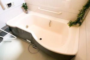 a white bath tub with plants on the wall at KODAKA Hotel TOKYO in Tokyo