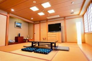 uma sala de estar com uma mesa e uma televisão de ecrã plano em KODAKA Hotel TOKYO em Tóquio