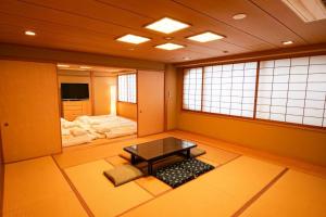 une chambre avec une table au milieu d'une pièce dans l'établissement KODAKA Hotel TOKYO, à Tokyo