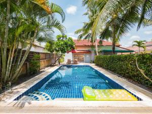 una piscina frente a una casa con palmeras en Lemon House apartment, en Mae Nam