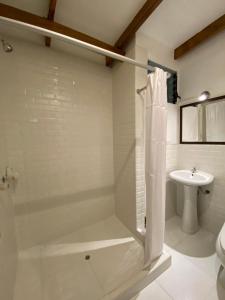 uma casa de banho com um chuveiro e um lavatório. em Mistico Machupicchu Eco B&B em Machu Picchu