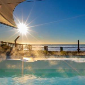 a hot tub with the ocean in the background at Wave side escape 1 bed 1 bath, New Brighton in Christchurch