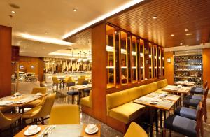 a restaurant with tables and chairs and a bar at Swiss-Belhotel Pondok Indah in Jakarta